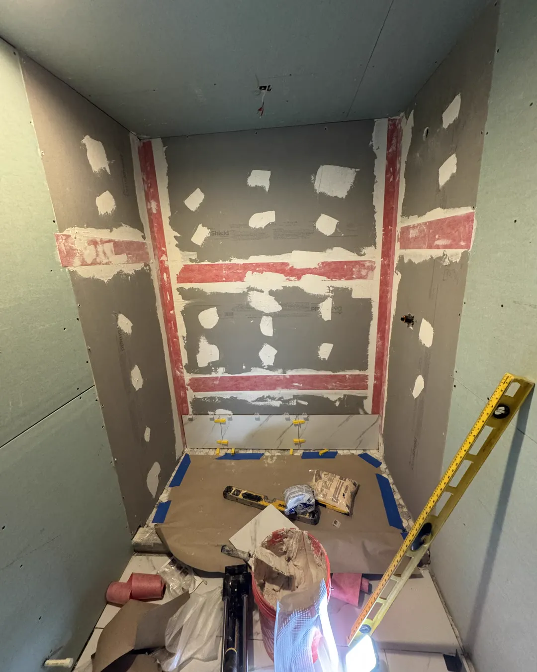 Shower walls covered in waterproofing membrane with every seam and corner banded