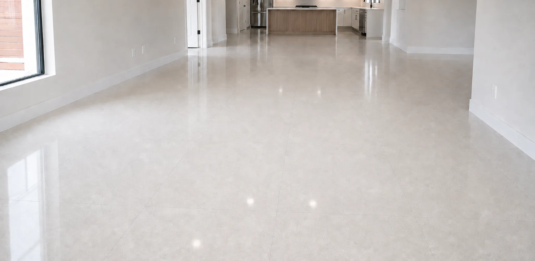 A polished light floor running through an open, empty room, flooring installation