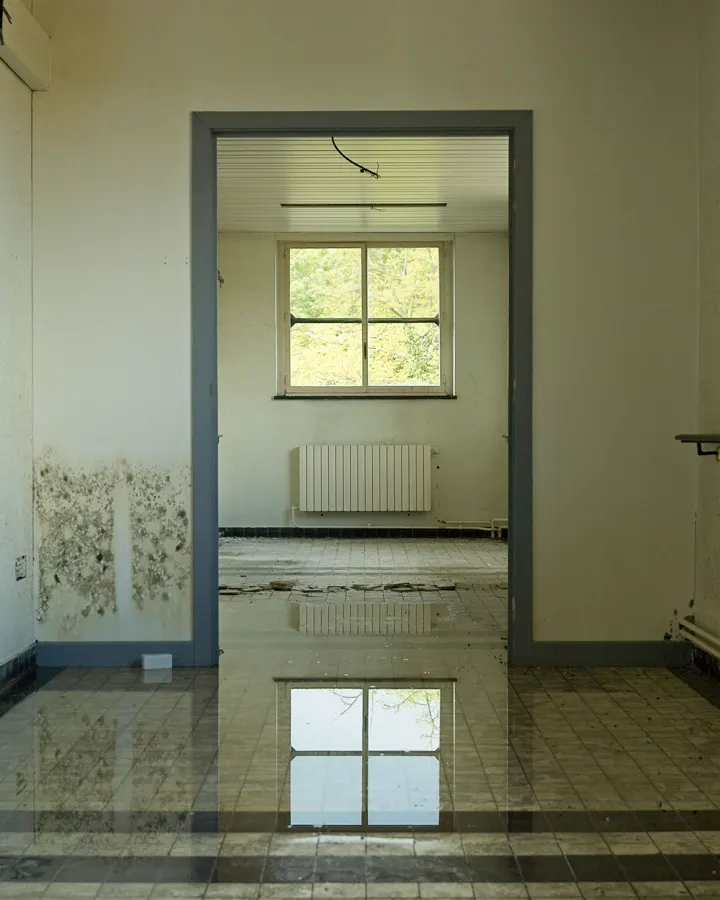 An empty room with a flooded floor reflecting the window, the case where an addition gets raised or not built