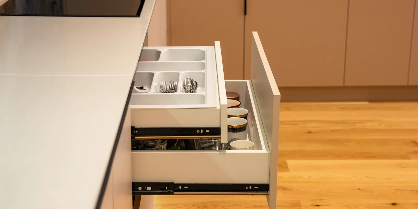 An open kitchen drawer with an organized cutlery divider, the finished detail a low bid skips