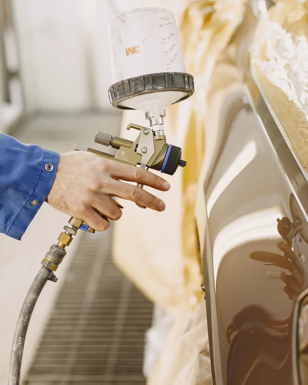 A spray gun laying a smooth coat on a cabinet door, cabinet painting