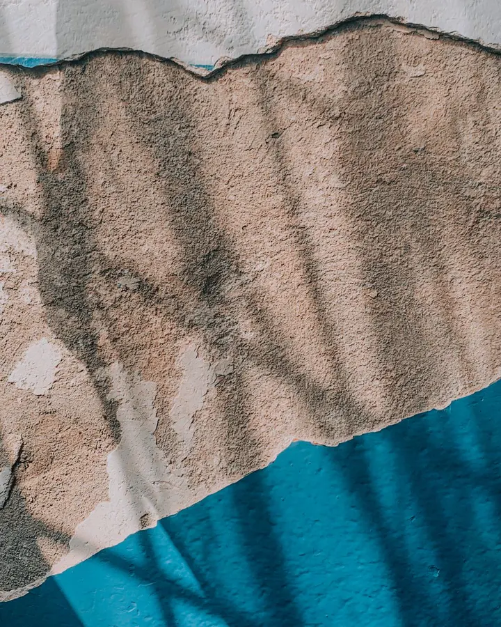 A wall with peeling paint and exposed plaster, the case where cabinets wait until the wall is fixed