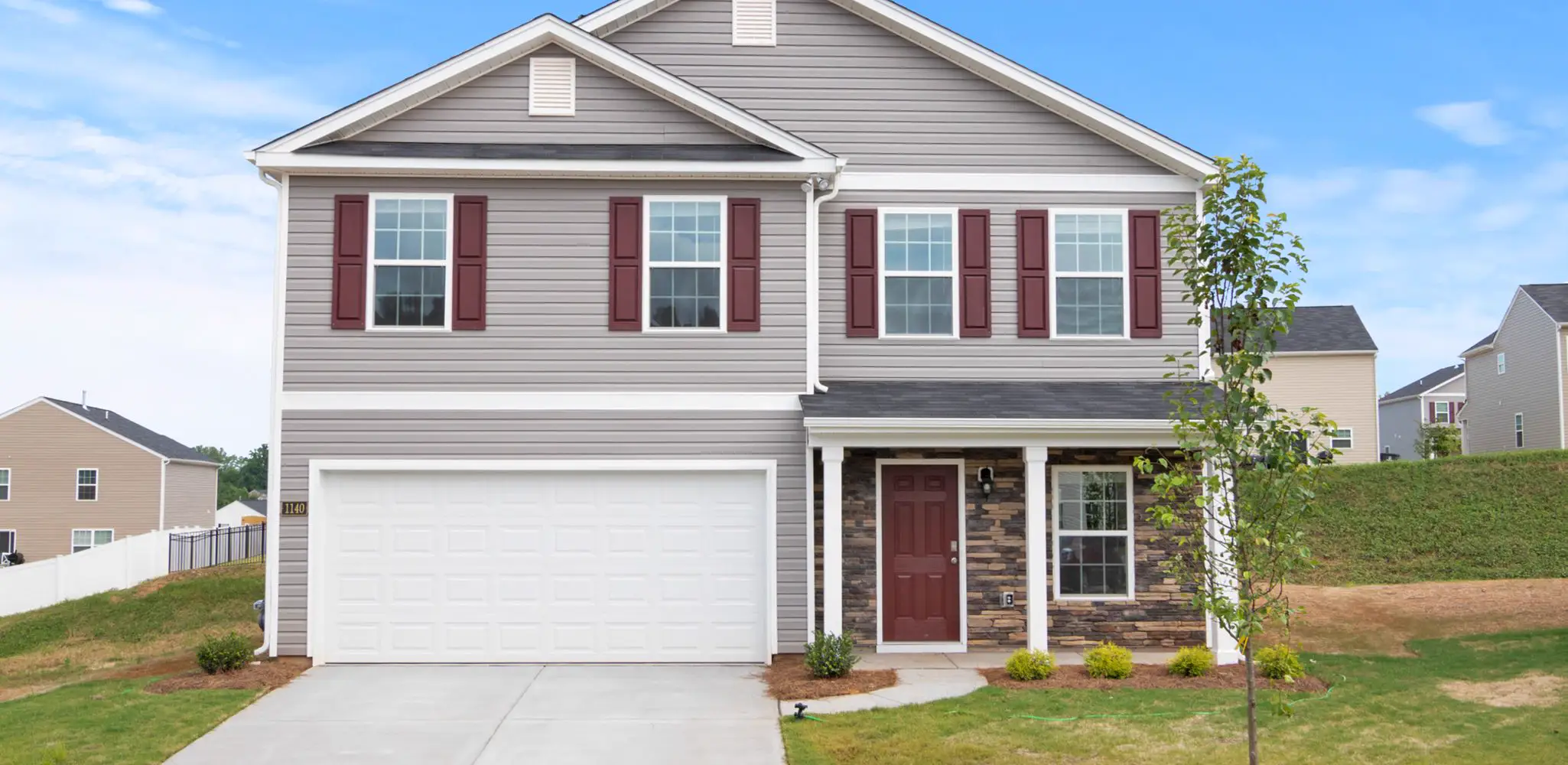 A house with a landscaped front yard and a concrete driveway, driveways
