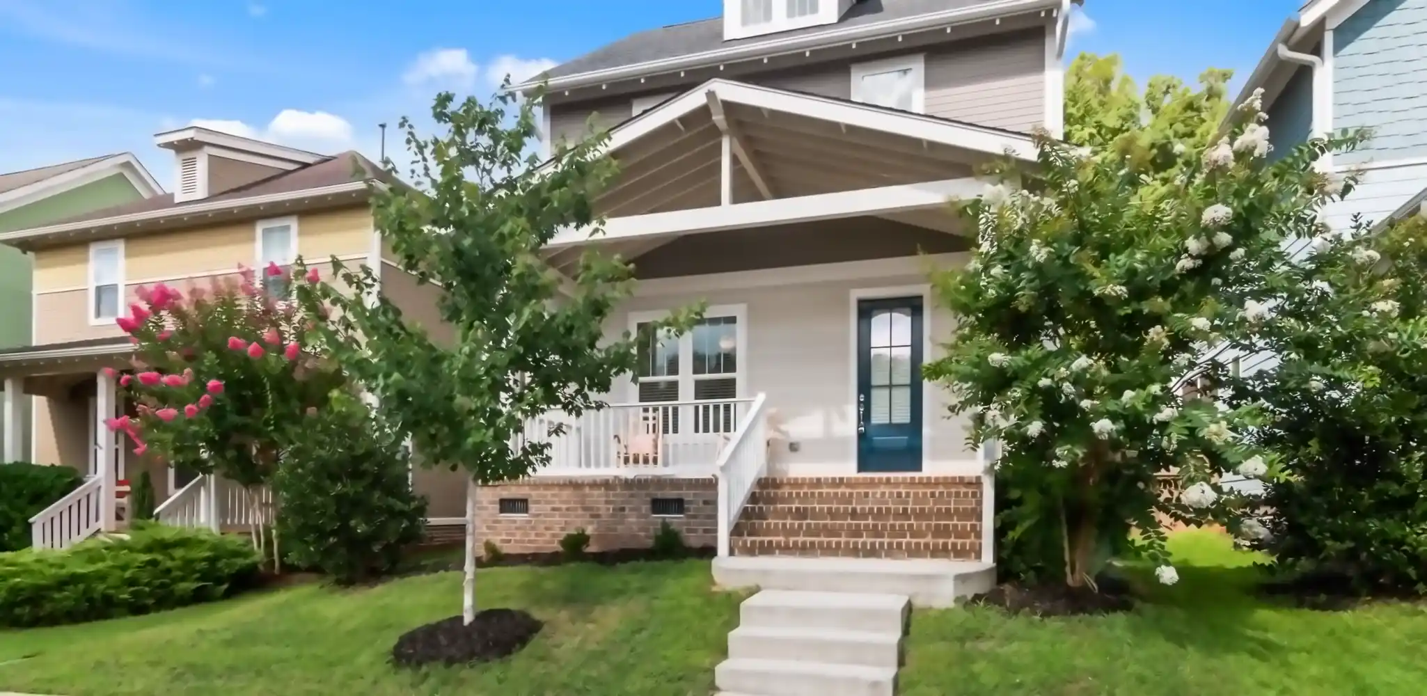 A house with a landscaped yard and a front porch, exterior and front of house
