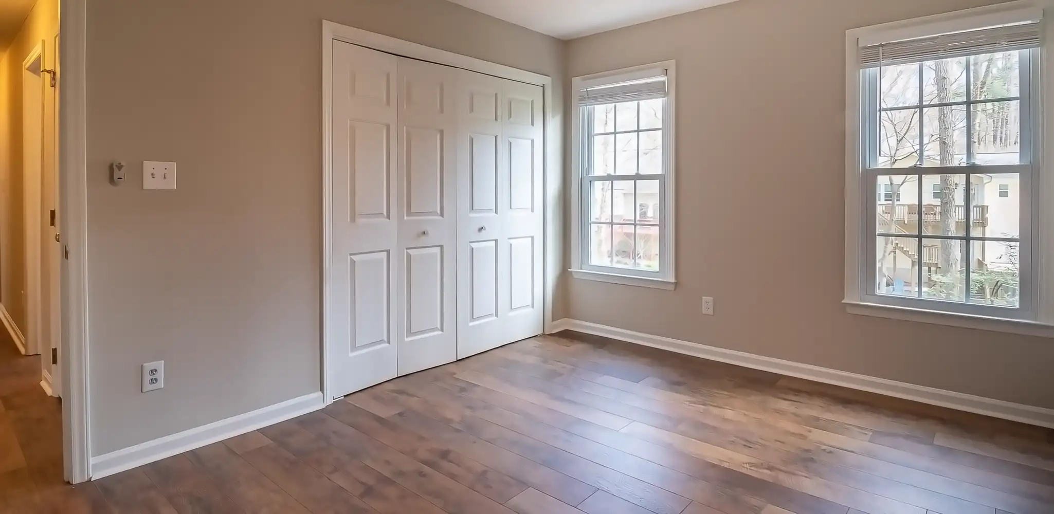An empty room with hardwood floors and a ceiling fan, flooring installation