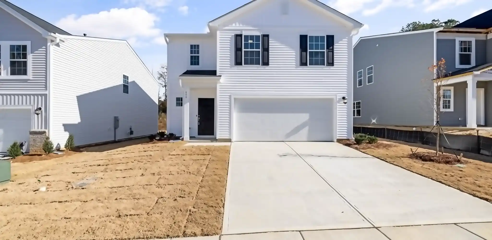 A white house with a garage and a clean driveway, driveways