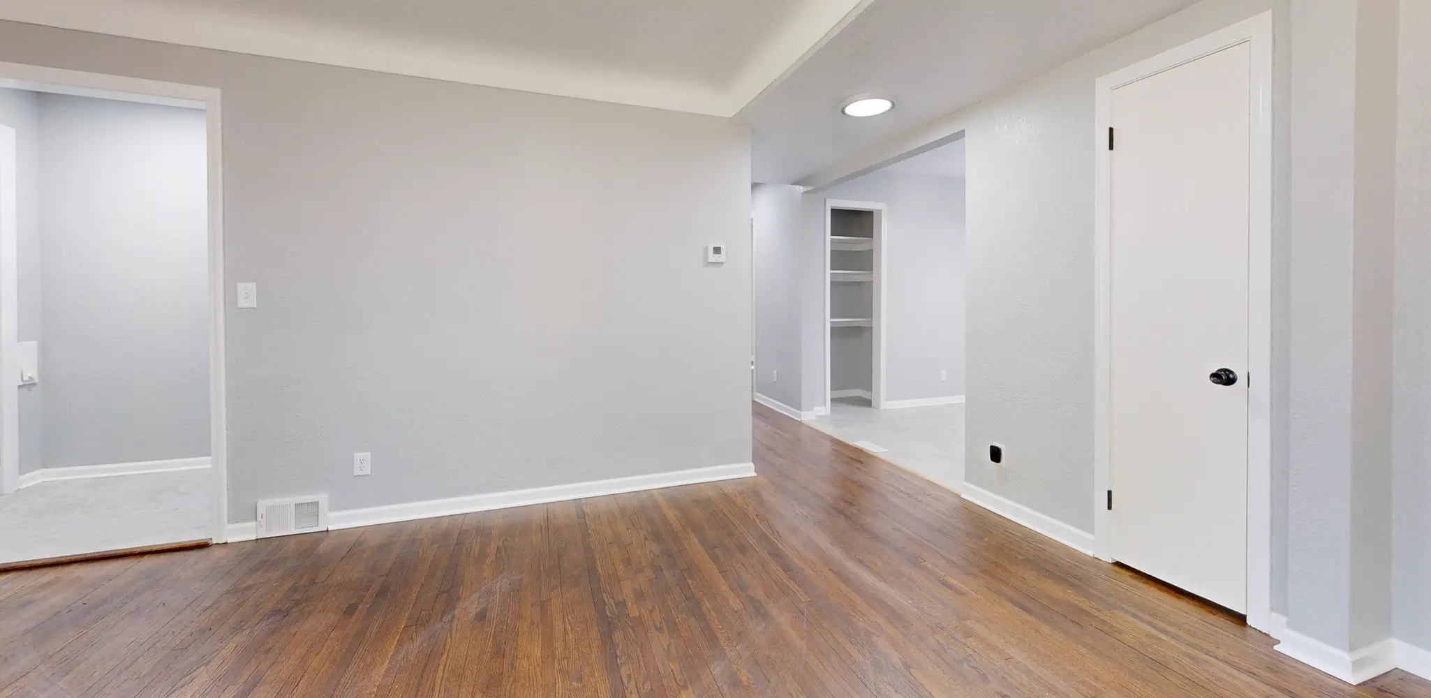 An empty room with a light wood floor, flooring installation
