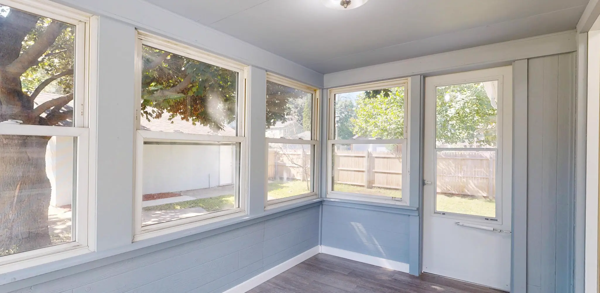 A sunroom with large windows and new floors, home additions