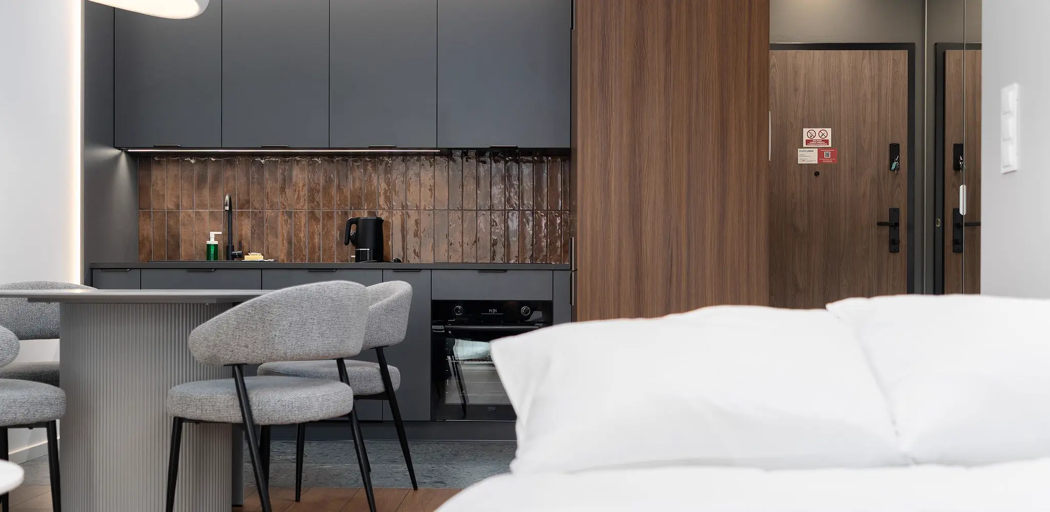 An apartment with a compact kitchen and a dining table, garage conversion
