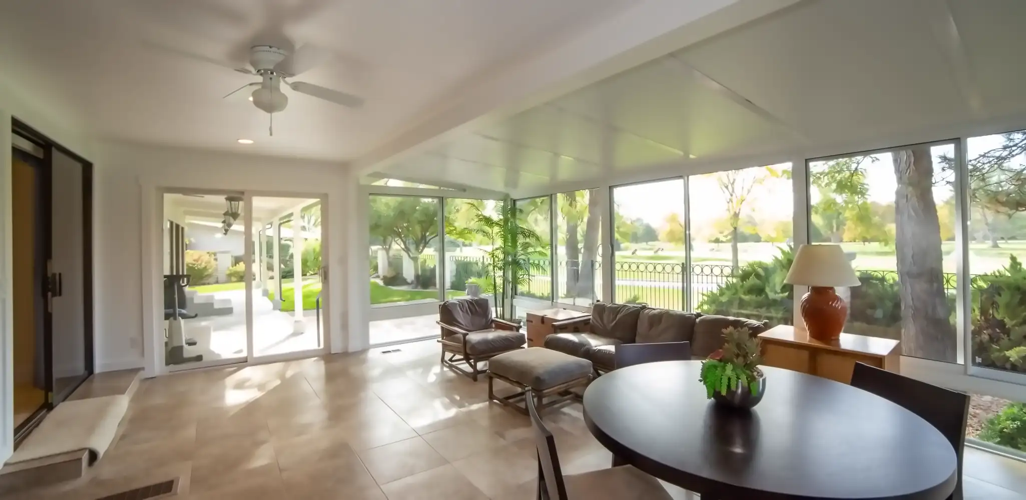 A sunroom with big windows and a view of the garden, home additions