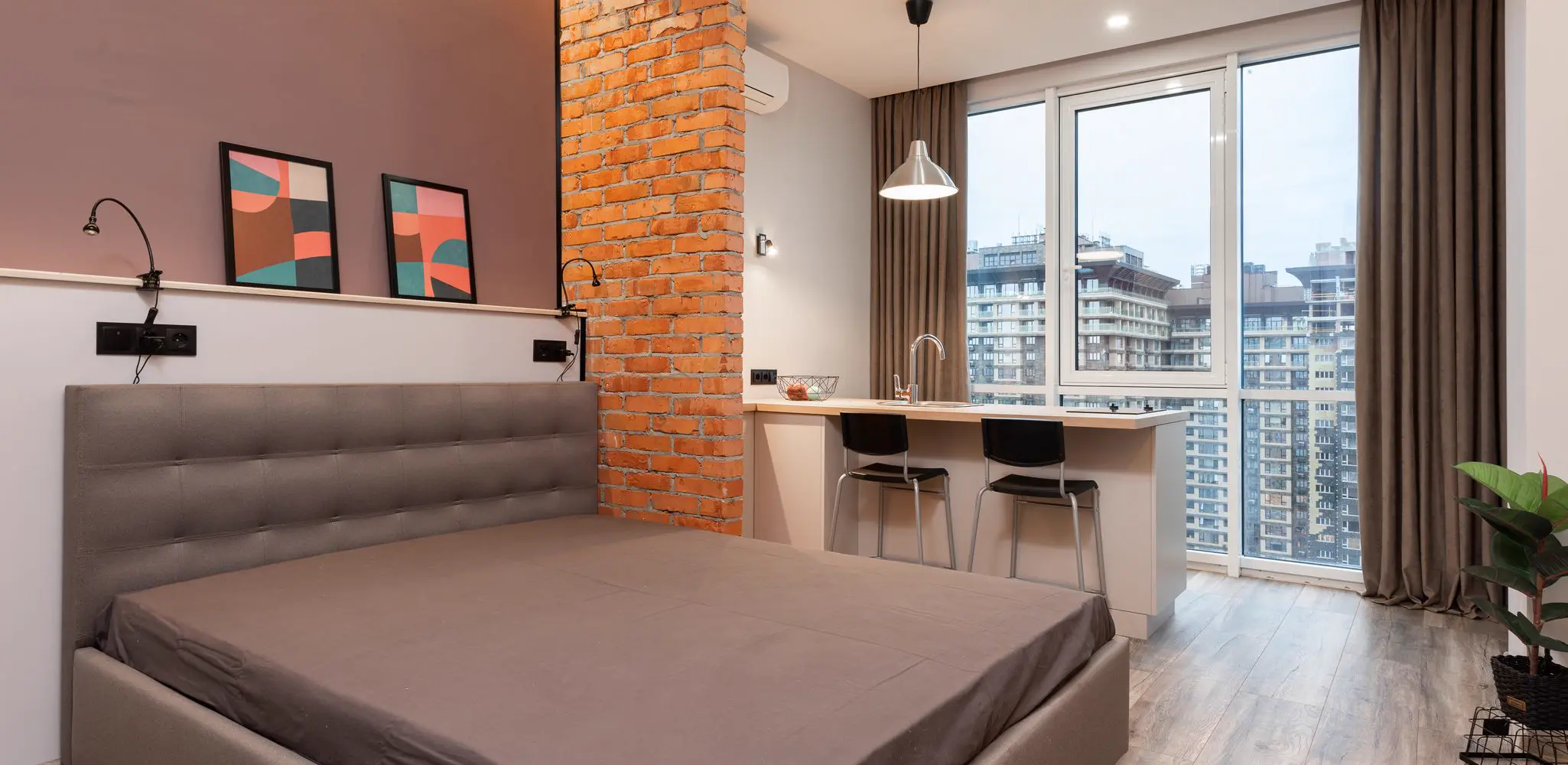 A light apartment with a bed near a counter with chairs, garage conversion