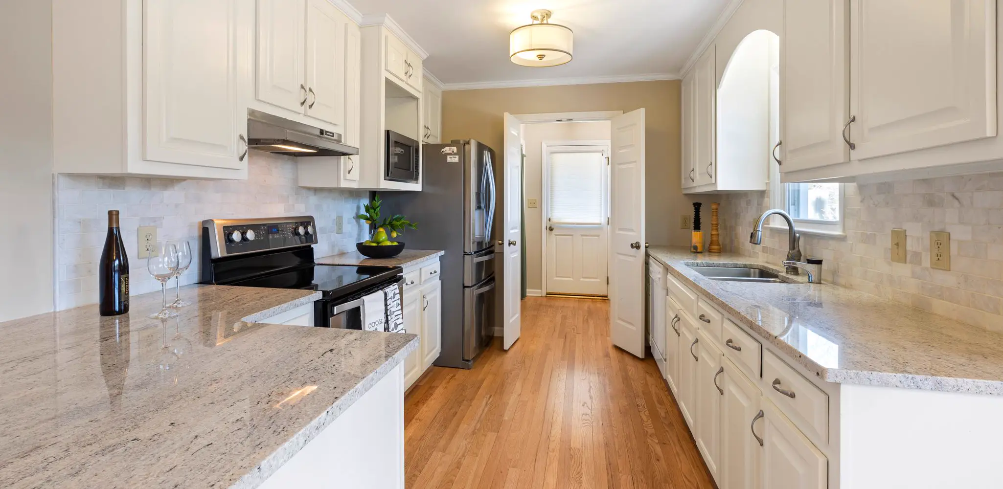 A white kitchen with long counters and new appliances, kitchen remodeling
