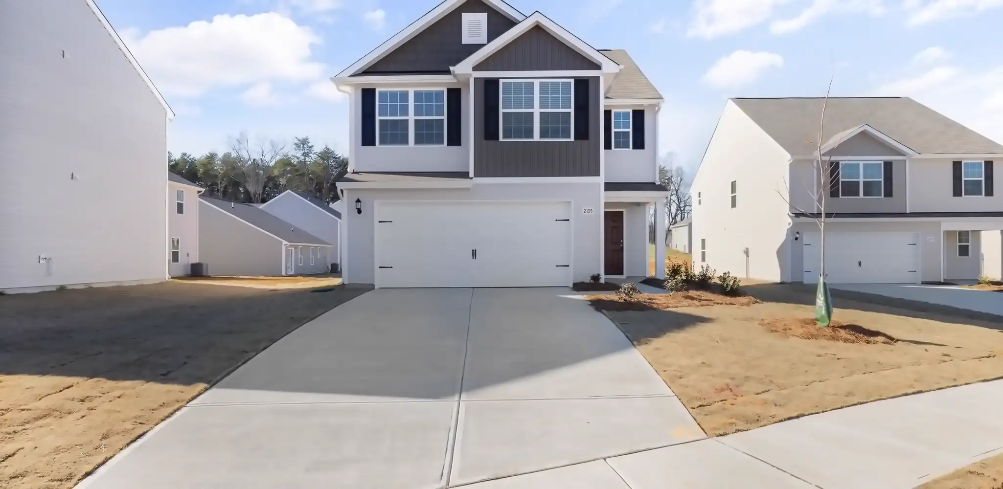 A two story house with a new concrete driveway, driveways