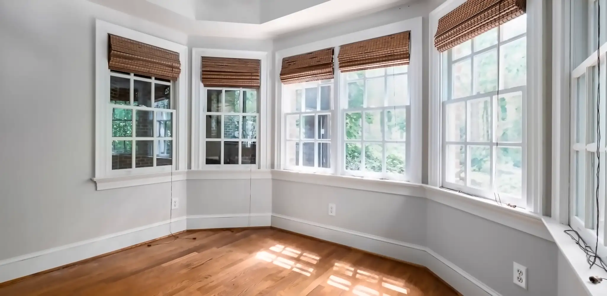A room with bay windows and a new wood floor, flooring installation
