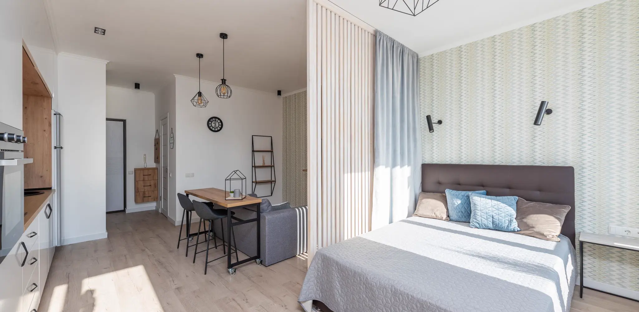 A studio with a bed, a sofa and white cabinets, garage conversion