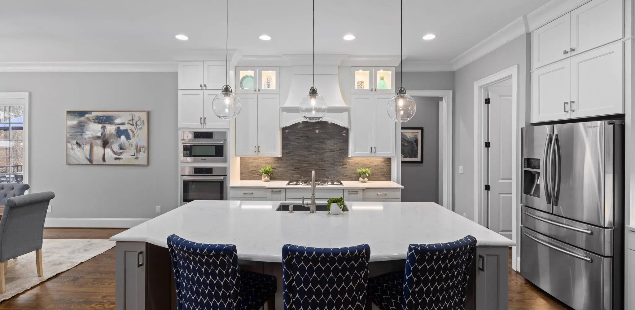 A bright kitchen with white cabinets and a dark island, kitchen remodeling