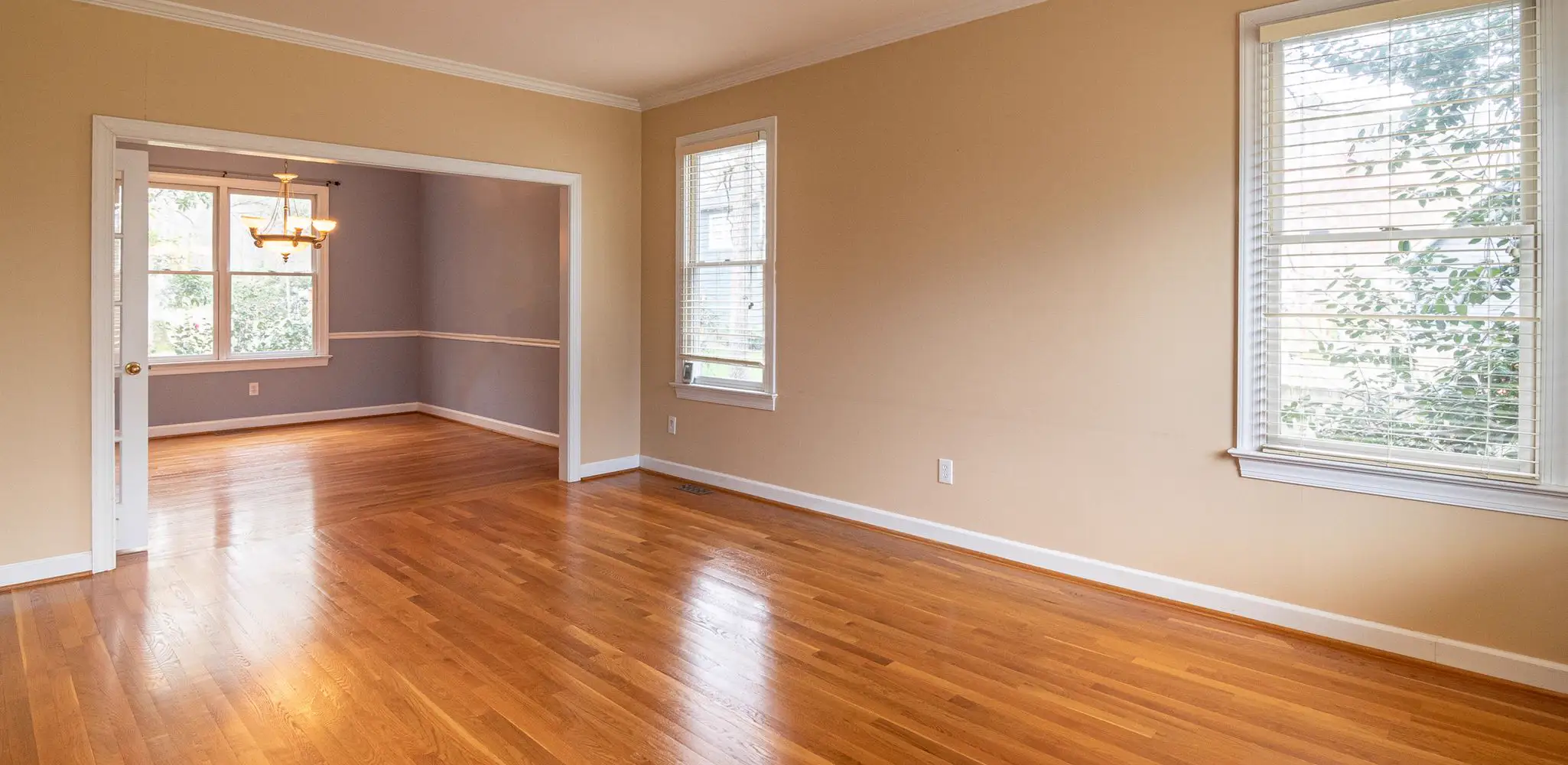 An empty room with wood floors and tall windows, flooring installation