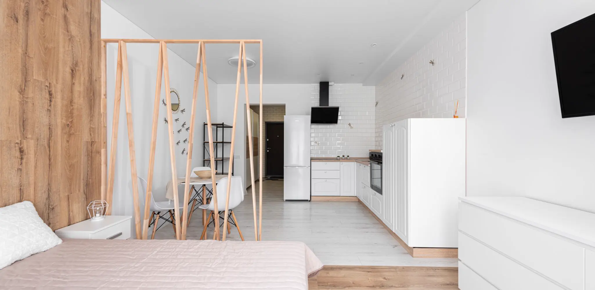A bedroom with a bed and a fridge in one open room, garage conversion