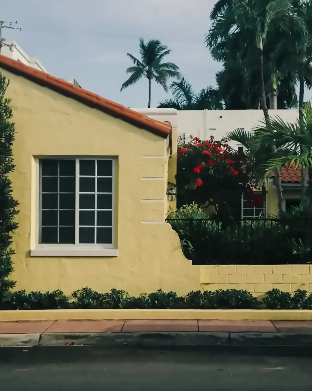 A yellow stucco house with a barrel tile roof and palms, the kind of house home remodeling in Clearwater, FL often starts with
