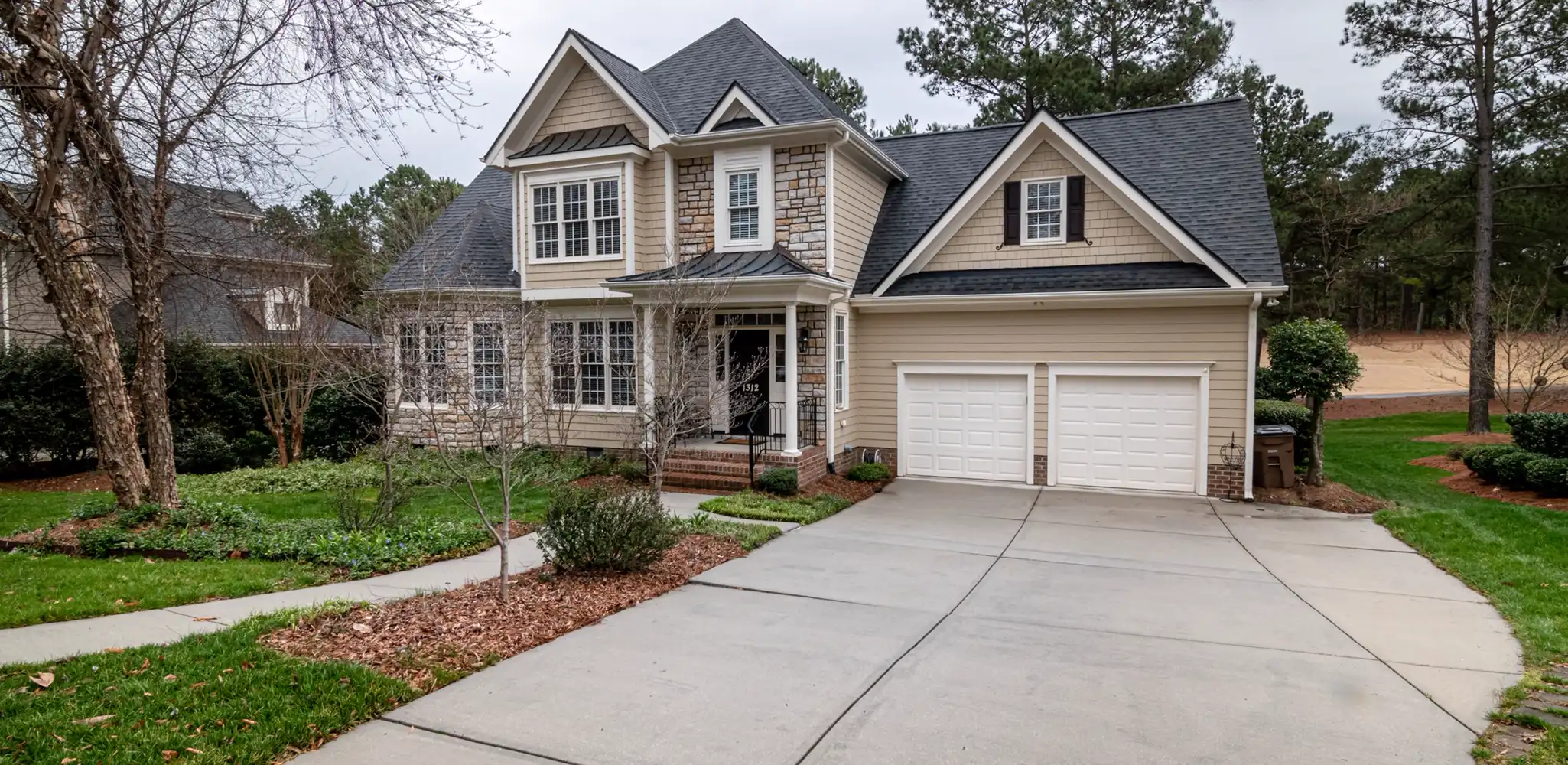 A fresh gray concrete driveway leading to a garage, concrete driveway replacement