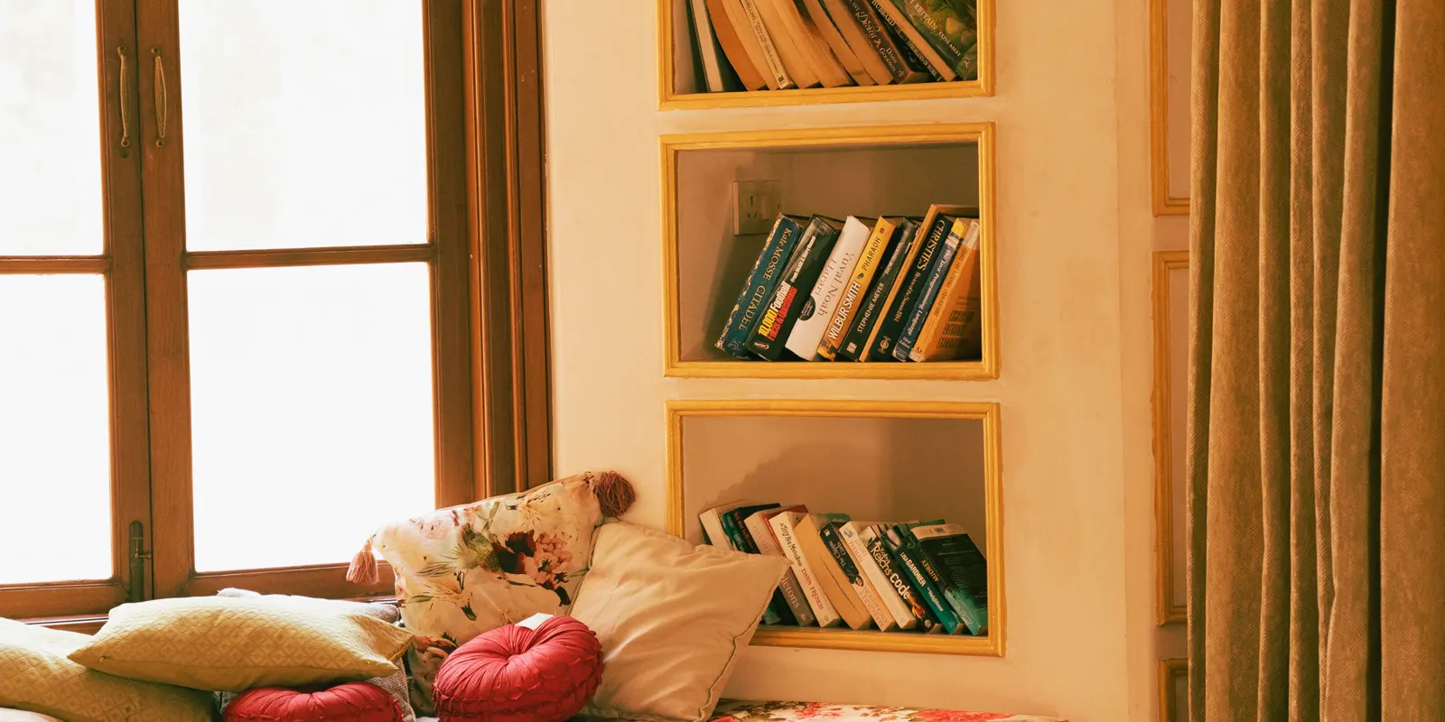 A reading nook with a cushioned window seat and built-in bookshelves, custom built-ins
