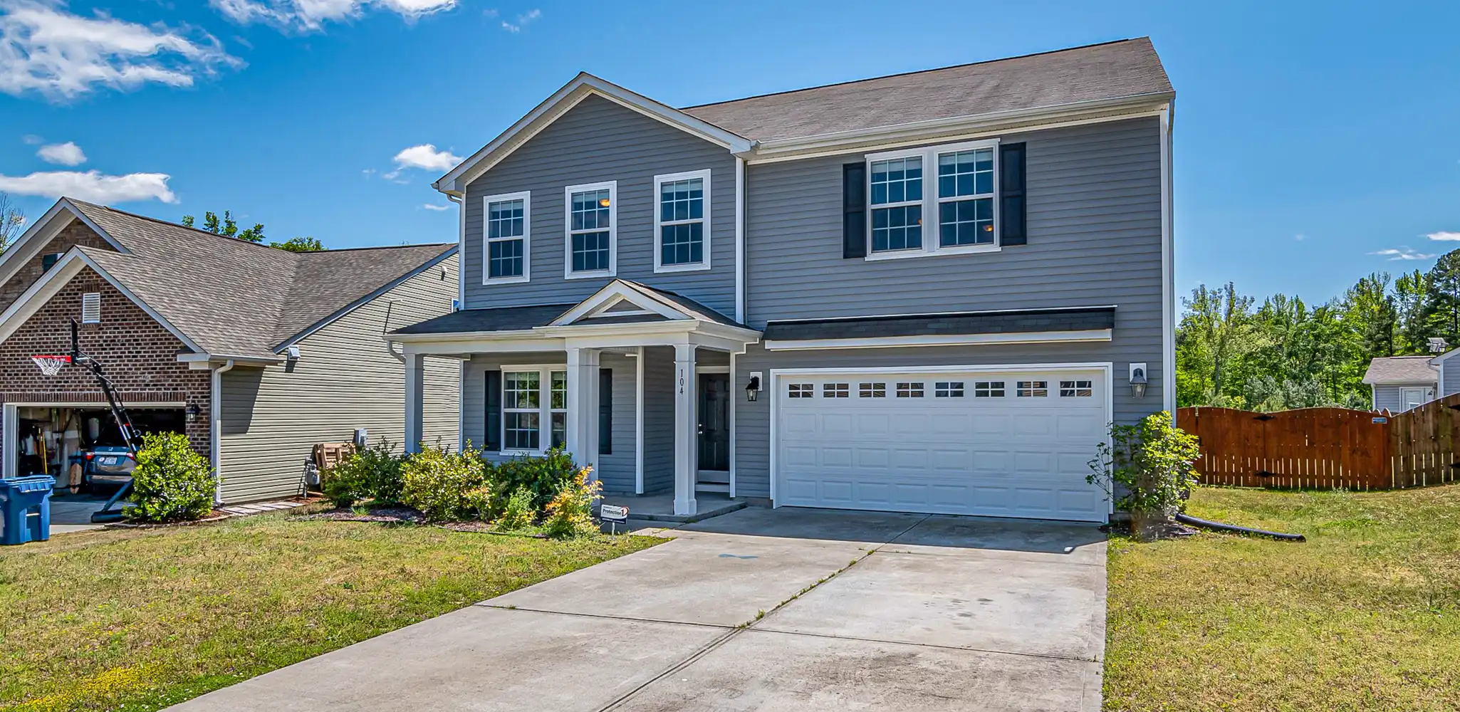 A house with a two car garage and a wide driveway, driveway cost