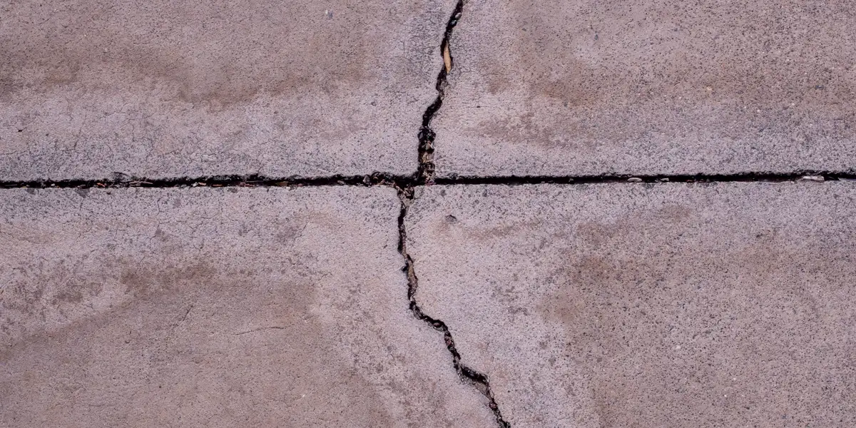 Close up of a crack running across a concrete surface, driveway repair