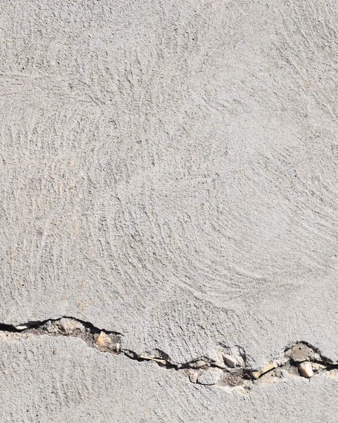 A cracked concrete slab with a crack running through it, driveway repair