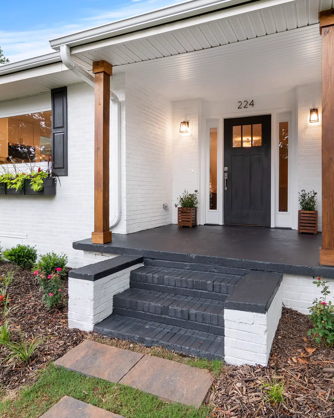 The front of a white house with a porch and a lawn, exterior remodel cost