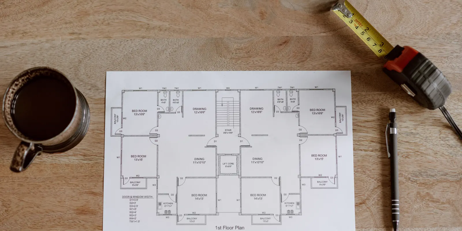 Architectural floor plans with a tape measure and a pencil on top, garage conversion cost