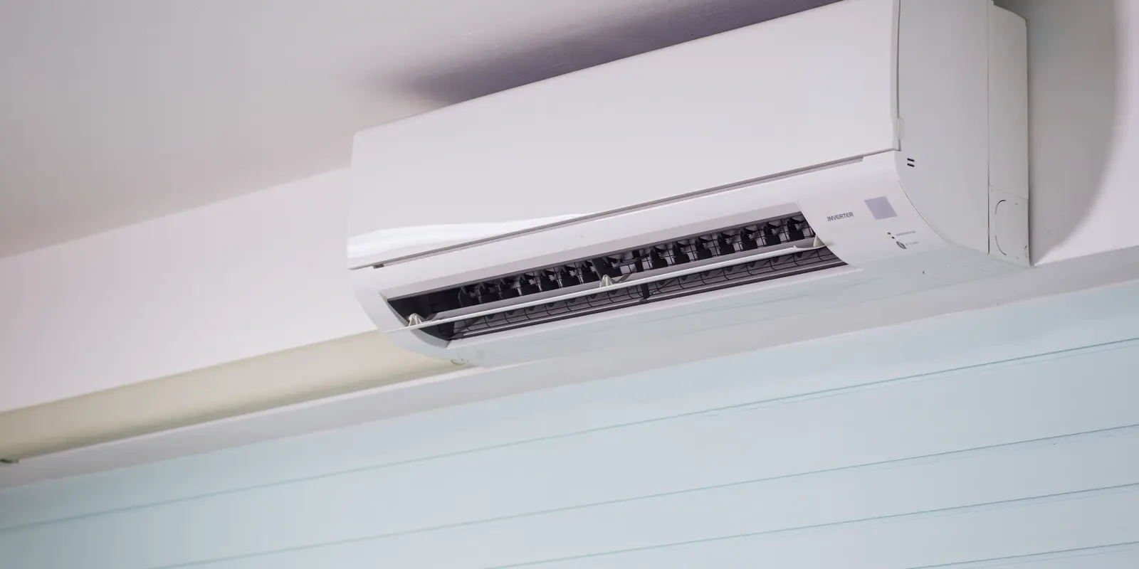 A wall mounted ductless mini-split indoor unit near the ceiling, garage conversion cost