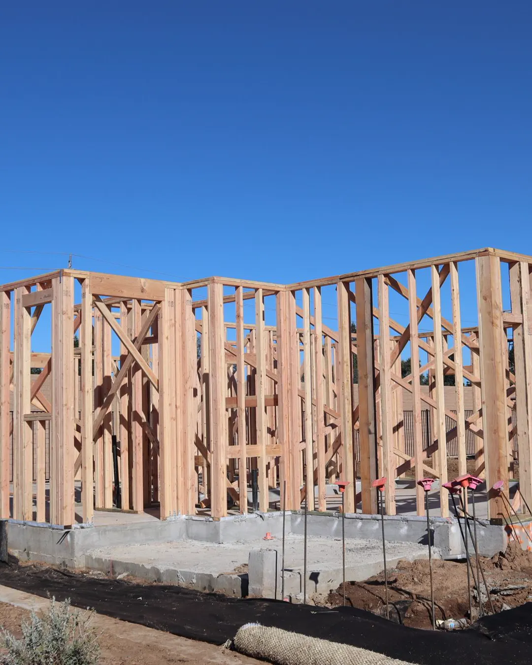 Wood framing of a house under construction on a sunny day, home addition cost