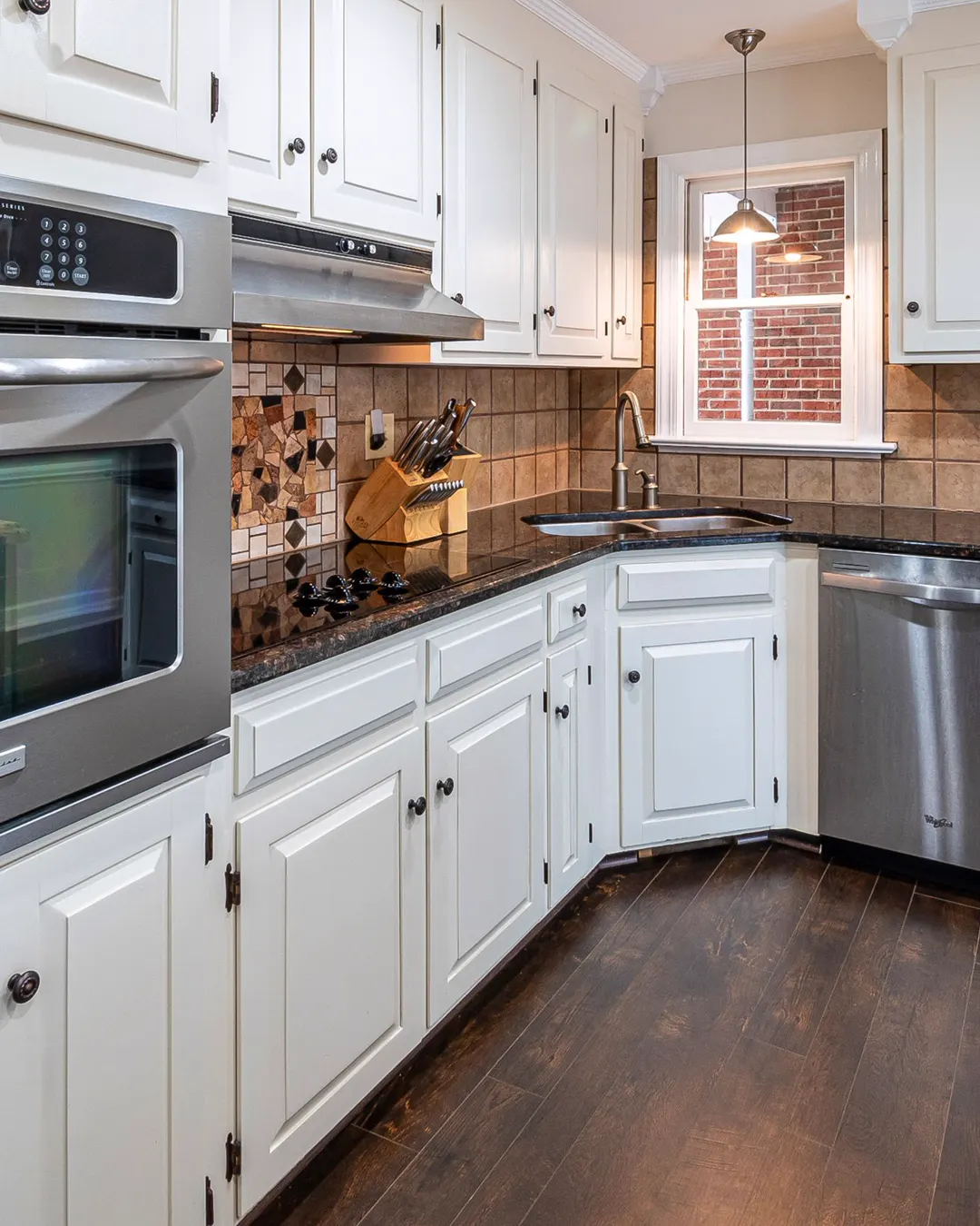 White kitchen cabinets set level and plumb with a tile backsplash, kitchen cabinet installation