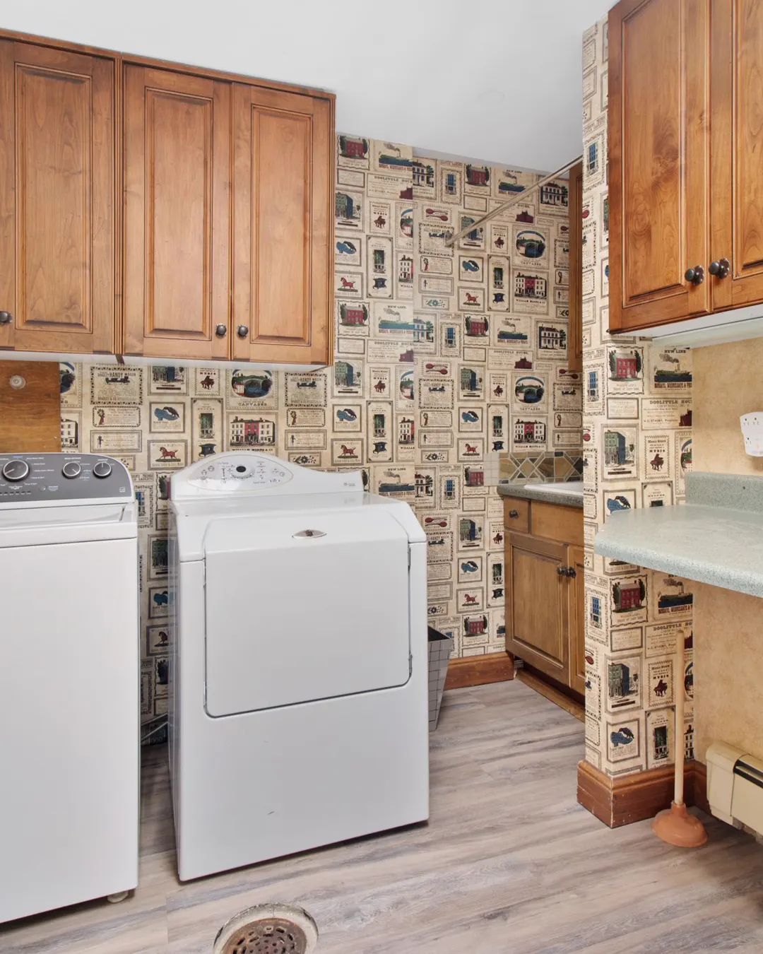 A laundry room with wooden cabinets over a washer and a dryer, laundry and garage cabinets