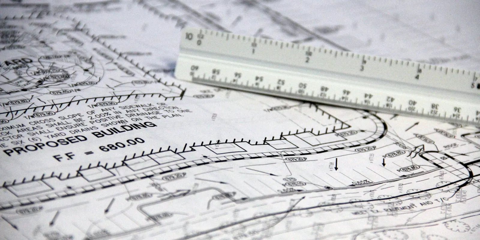 A close-up of architectural blueprints with a scale ruler, master suite addition
