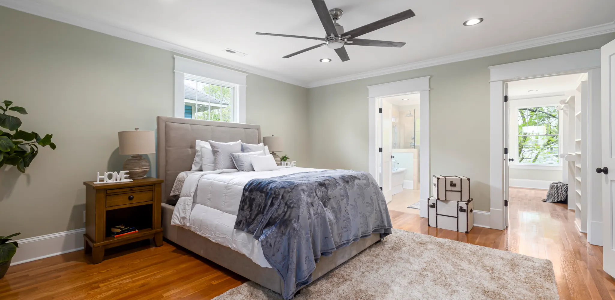 A bedroom with a ceiling fan and soft natural light, the finished side of a master suite addition