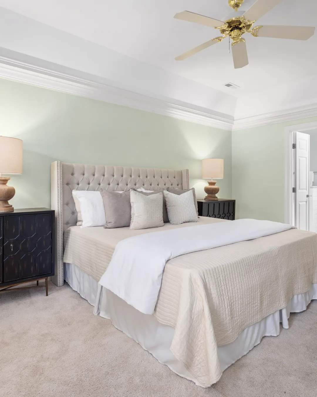 A spacious bedroom with a king bed, two lamps and natural light, master suite addition