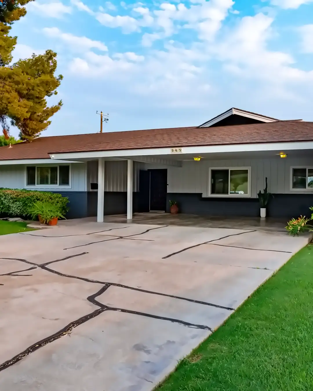 A low one story house from the 1960s with a covered entry and a cracked concrete driveway, the kind of house home remodeling in New Port Richey, FL often starts with