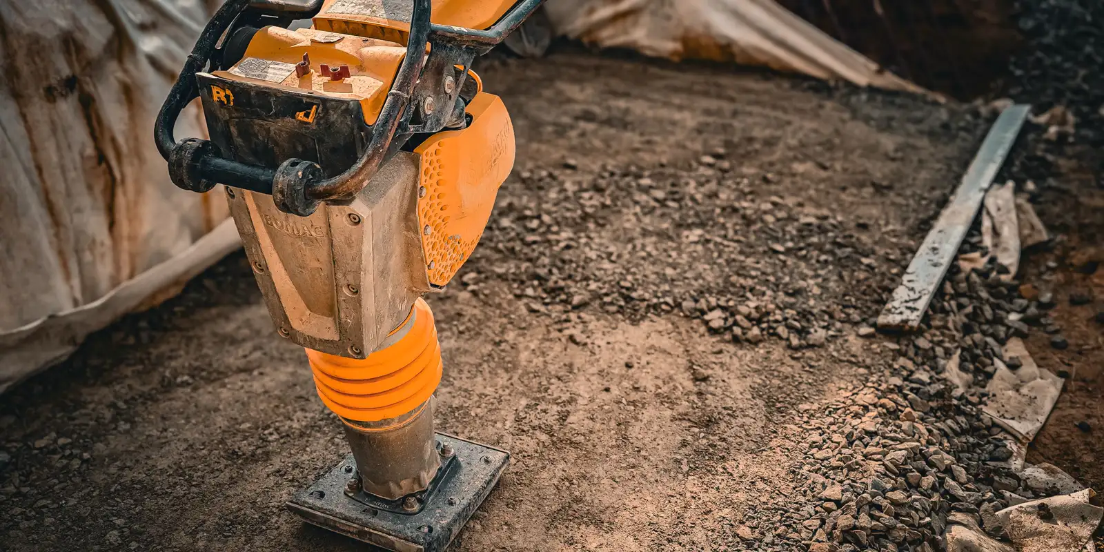 Close up of a vibratory plate compactor on a base, paver driveway
