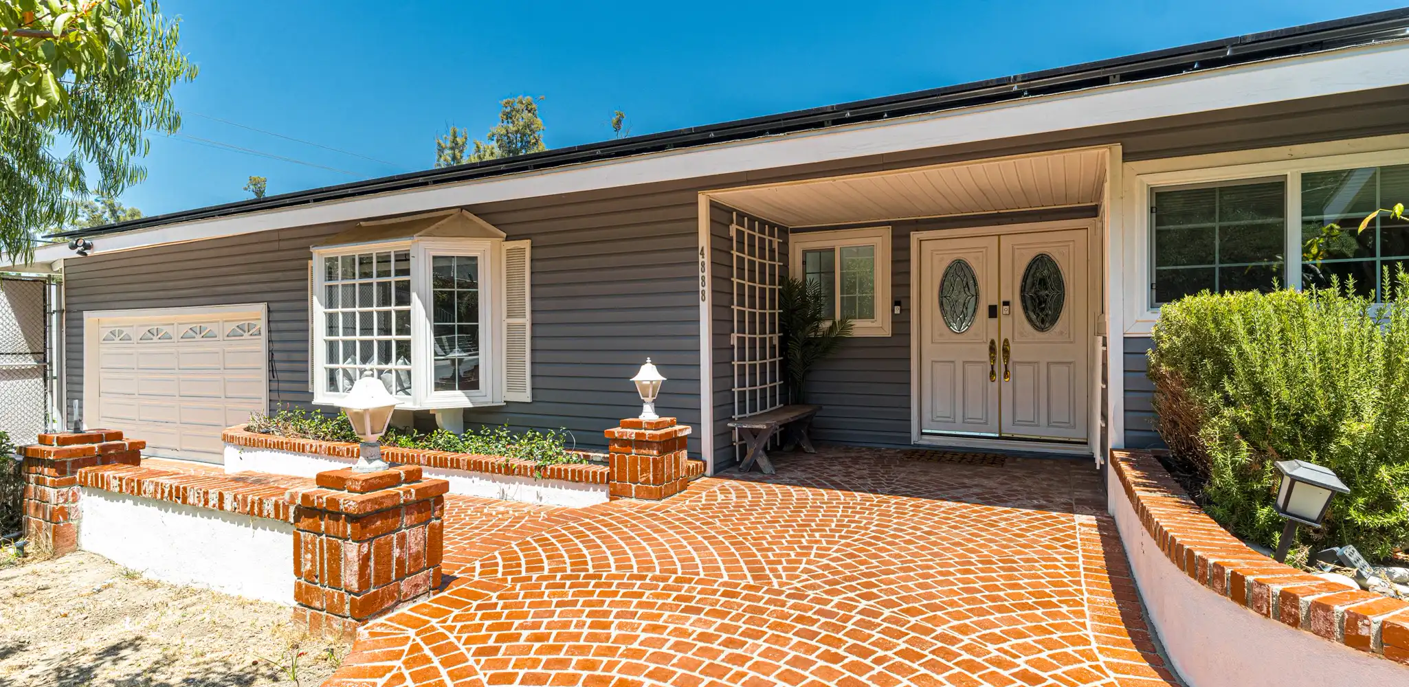 A red brick paver driveway and walkway in front of a house, paver driveway