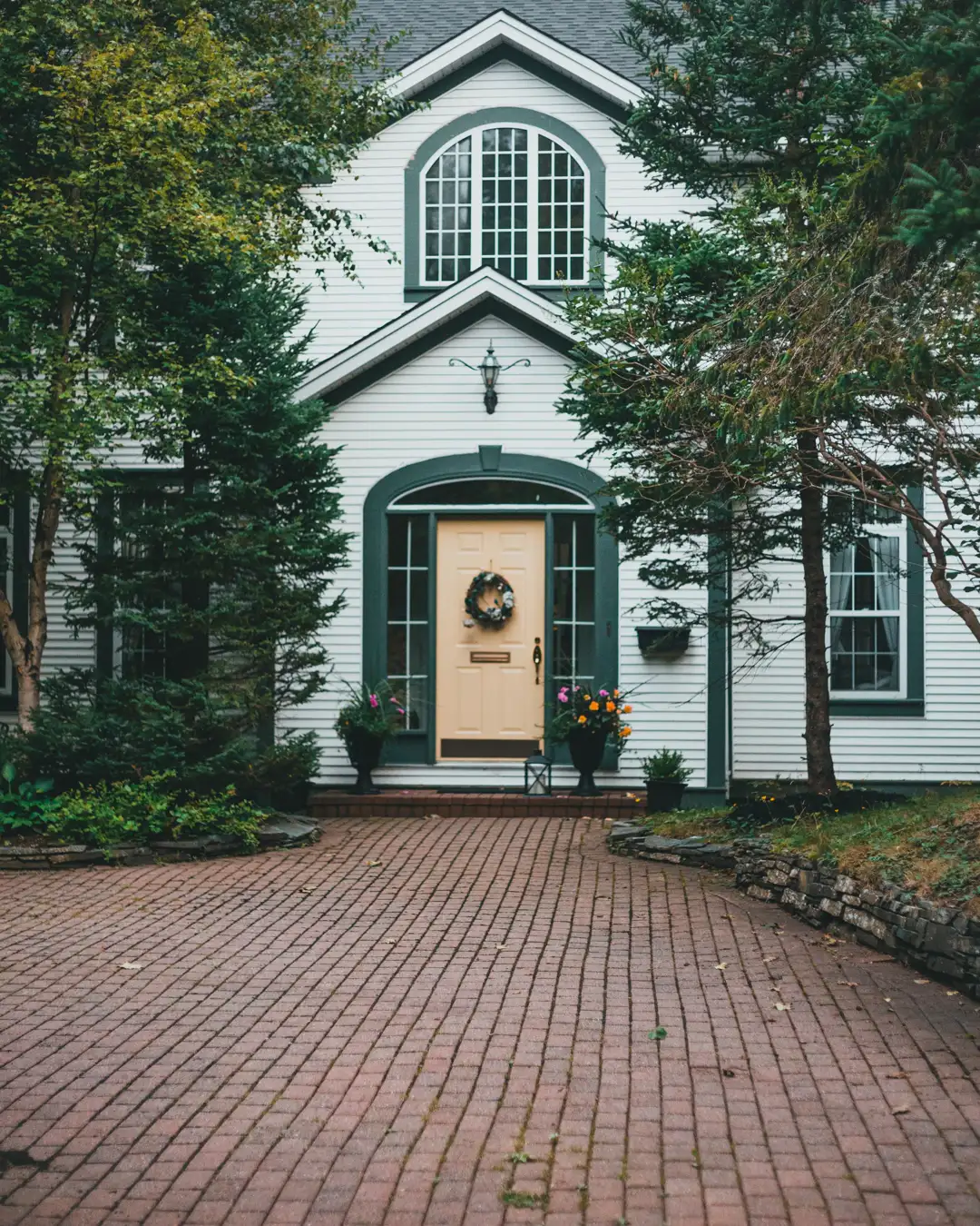 A brick paver driveway leading to a home with a walkway, paver driveway installation