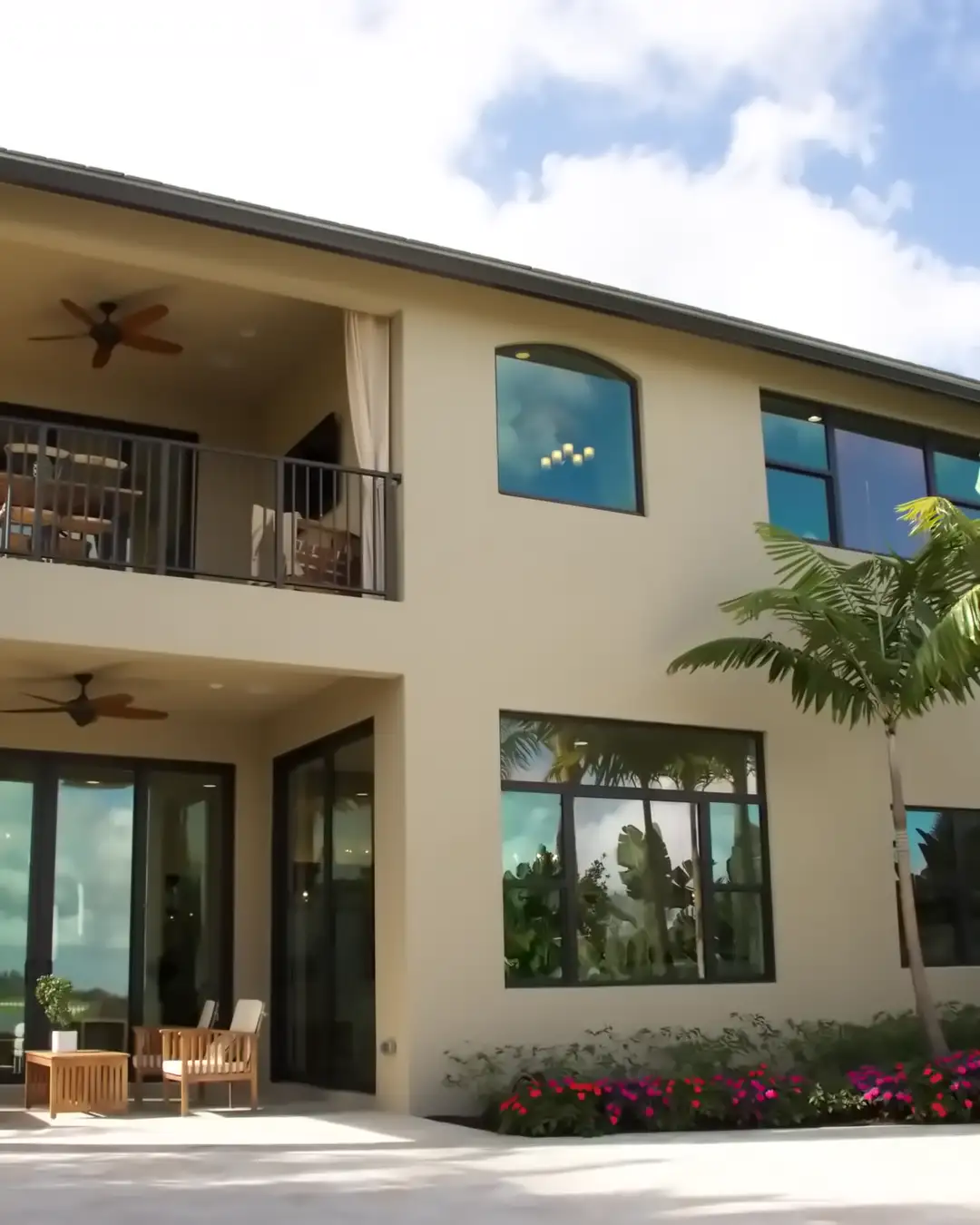 A two story stucco house with a balcony, a covered patio and a palm, the kind of house home remodeling in Riverview, FL often starts with