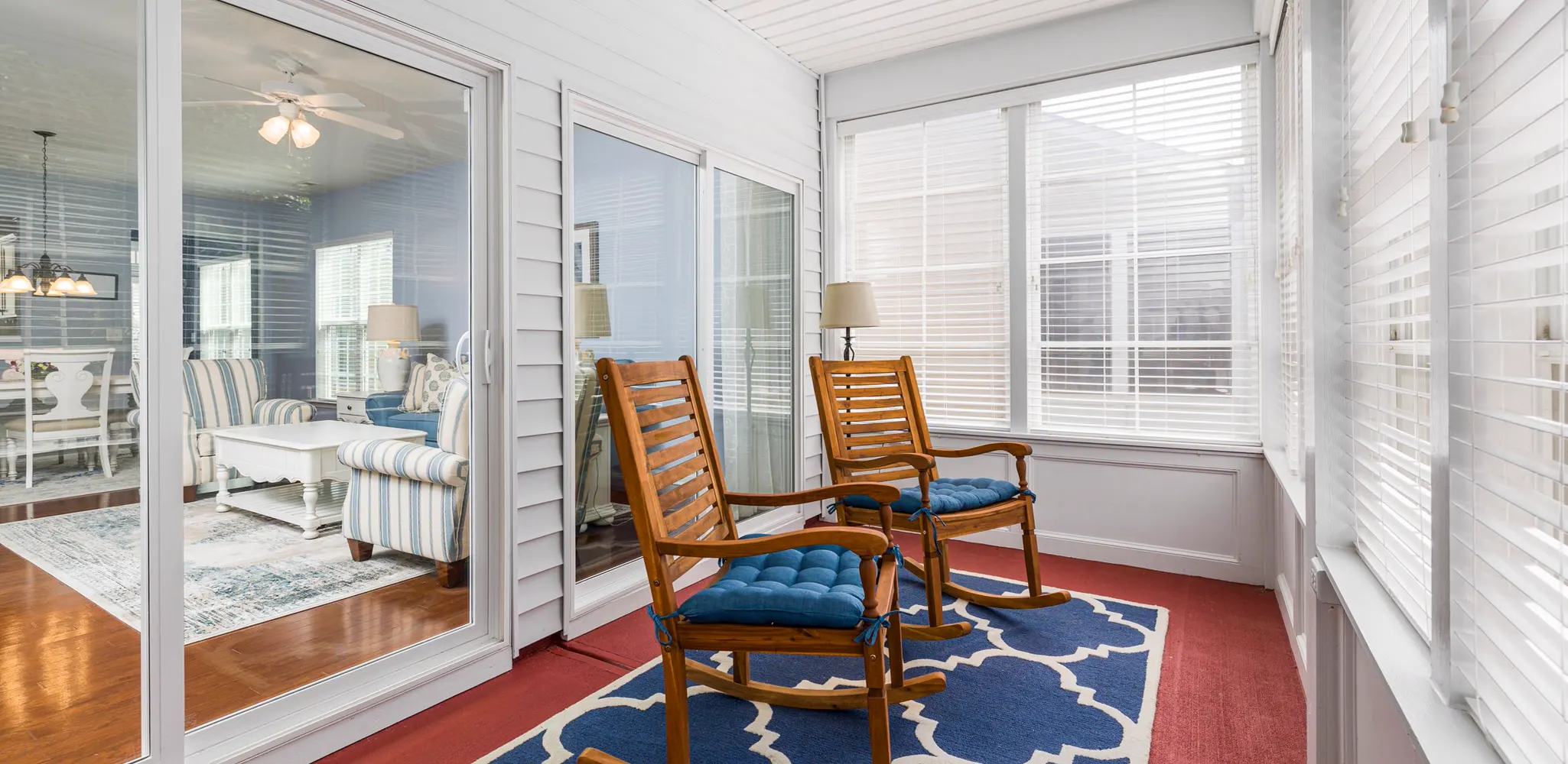 A sunroom with rocking chairs and glass doors opening to the house, the finished side of a sunroom addition