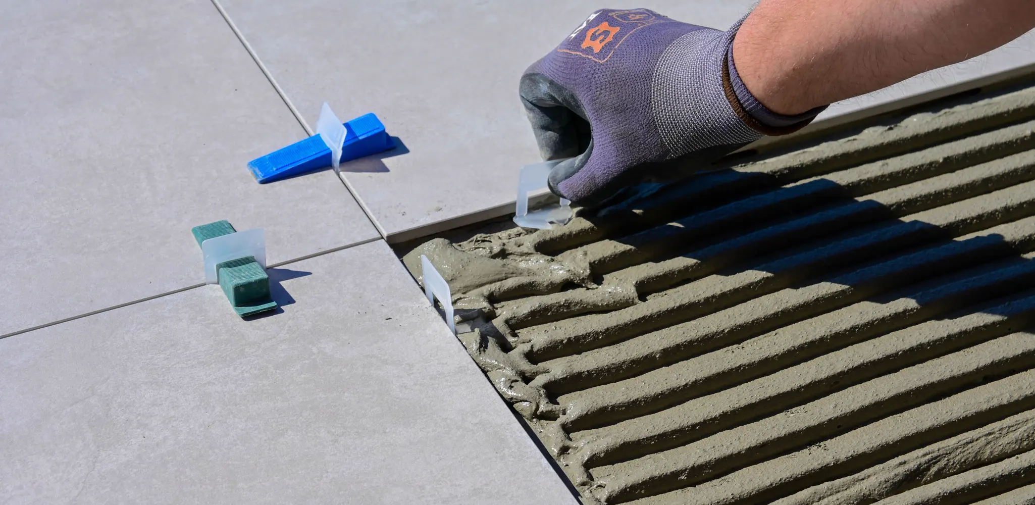 Floor tile set in fresh mortar with leveling clips, tile flooring installation